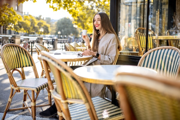 Woman drinking coffee at an outdoor cafe in Paris