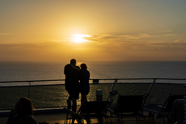 couple watching a sunset from a cruise ship